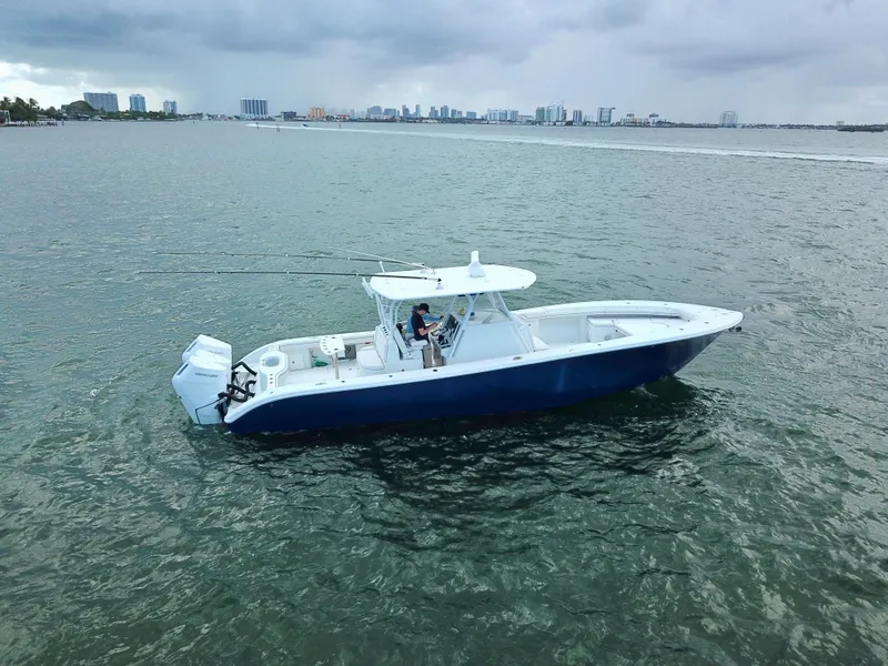 Slide: The Image of 2017 Yellowfin 39 Offshore boat on calm water with city skyline in background. - 5