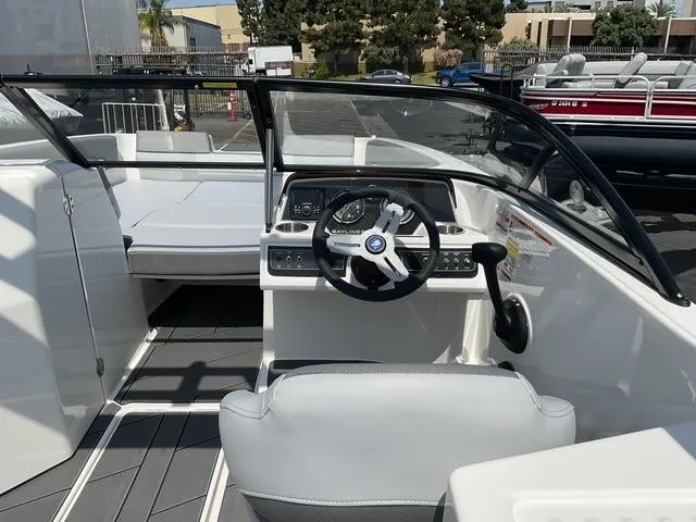 Slide: The Image of 2025 Bayliner D22 boat interior with steering wheel and seating, showcasing modern design. - 11