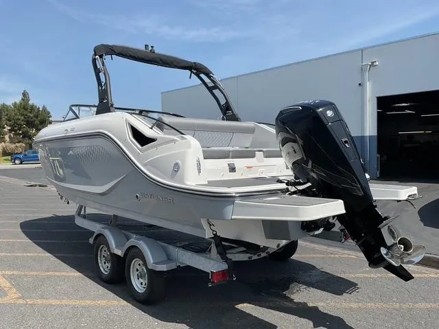 Slide: The Image of 2025 Bayliner D22 boat on trailer, parked outdoors near a building. - 2