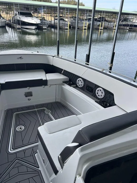 Slide: The Image of 2023 Monterey 378SS boat interior with seating and speakers, docked at a marina. - 25