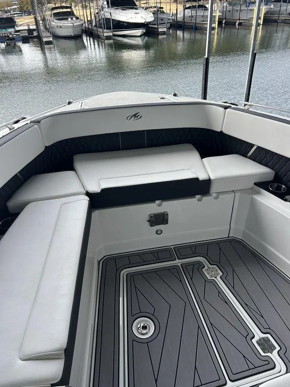 Slide: The Image of 2023 Monterey 378SS boat interior with sleek seating and modern design on a calm lake. - 23