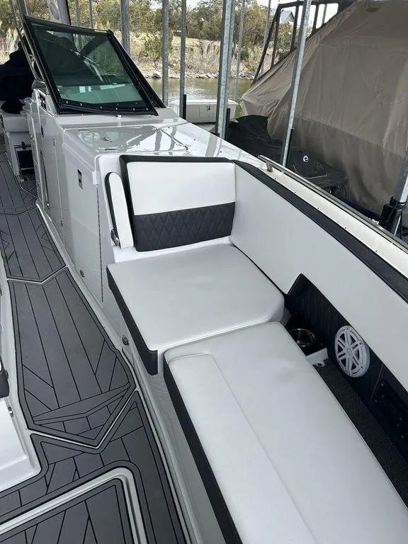 Slide: The Image of 2023 Monterey 378SS boat interior with cushioned seating, docked at a marina. - 31