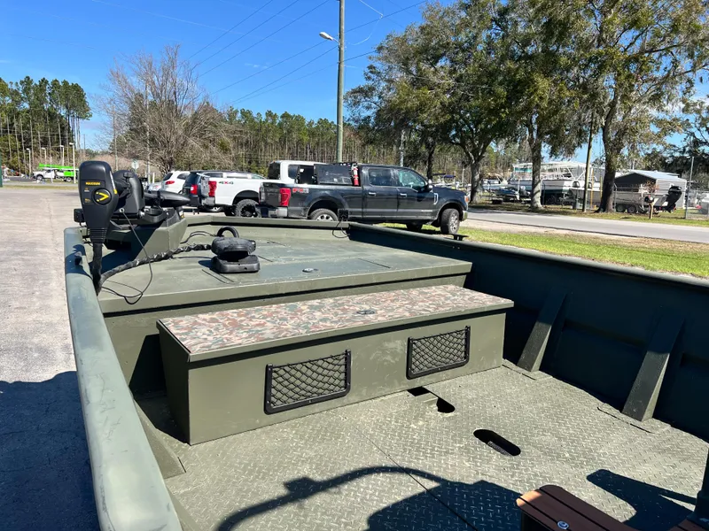 Slide: The Image of 2012 SeaArk 1872 boat with camouflage seating, parked outdoors. - 11