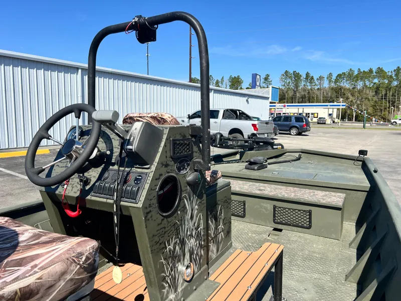 Slide: The Image of 2012 SeaArk 1872 boat interior with steering console, parked outdoors. - 15