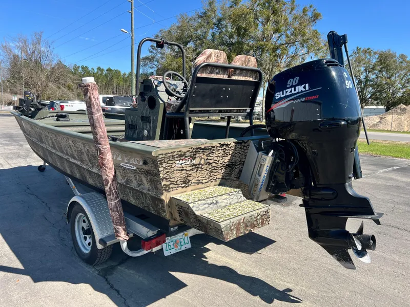 Slide: The Image of 2012 SeaArk 1872 boat with Suzuki 90 engine on trailer, parked outdoors. - 8