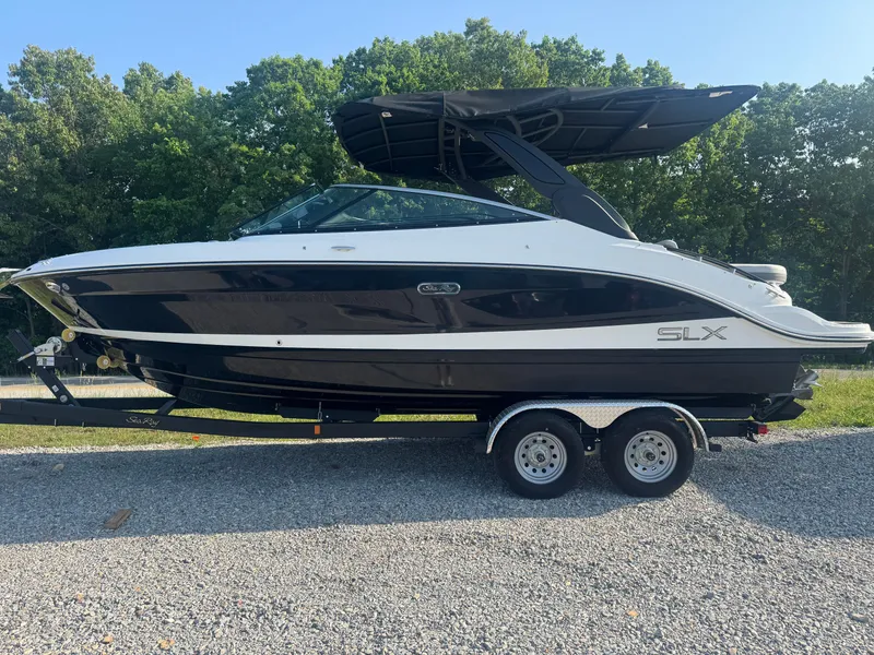 The Image of 2025 Sea Ray SLX 260 boat on trailer, black and white design, parked outdoors. - 1