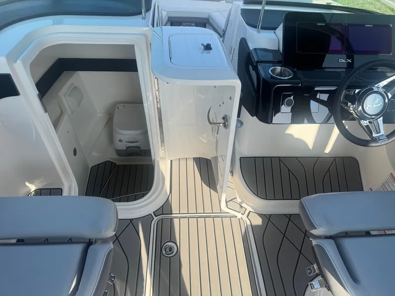 Slide: The Image of 2025 Sea Ray SLX 260 boat interior with helm, seating, and cabin area. - 21