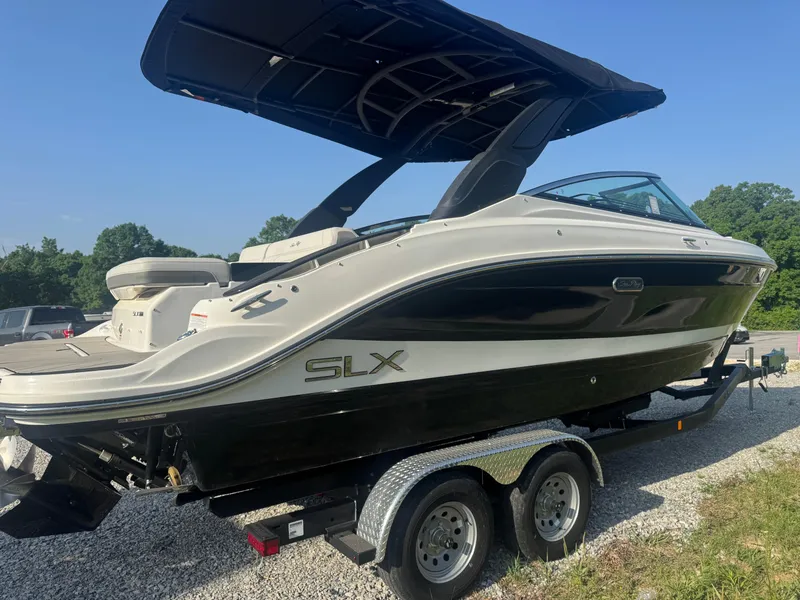 Slide: The Image of 2025 Sea Ray SLX 260 boat on trailer, black and white design, sunny day. - 5