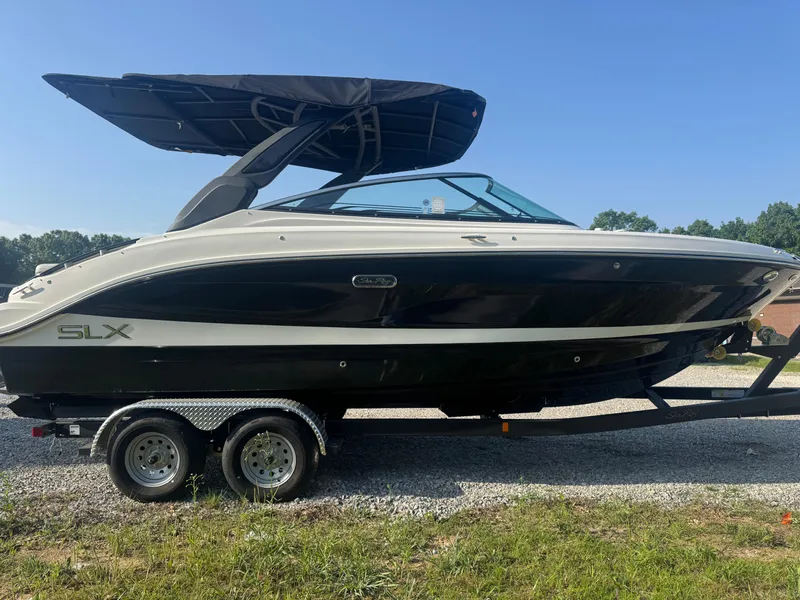Slide: The Image of 2025 Sea Ray SLX 260 boat on trailer, black and white design, parked outdoors. - 6