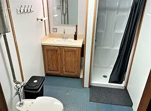 Slide: The Image of Bathroom interior of a 2002 custom offshore supply vessel, featuring a shower, sink, and toilet. - 13