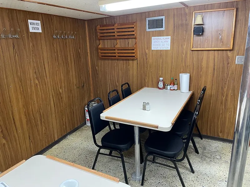 Slide: The Image of Dining area on a 2002 Custom Offshore Supply Vessel with wooden walls and seating. - 6