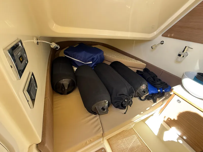 Slide: The Image of Interior of 2022 Chris-Craft Catalina 30 with storage items on a cushioned seat. - 12