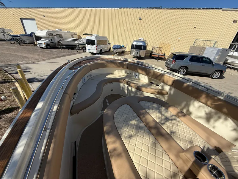 Slide: The Image of 2022 Chris-Craft Catalina 30 boat with luxurious seating, parked near RVs and vehicles. - 13