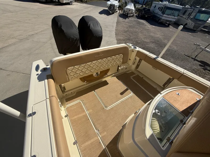 Slide: The Image of 2022 Chris-Craft Catalina 30 boat interior with tan upholstery and covered engines. - 5