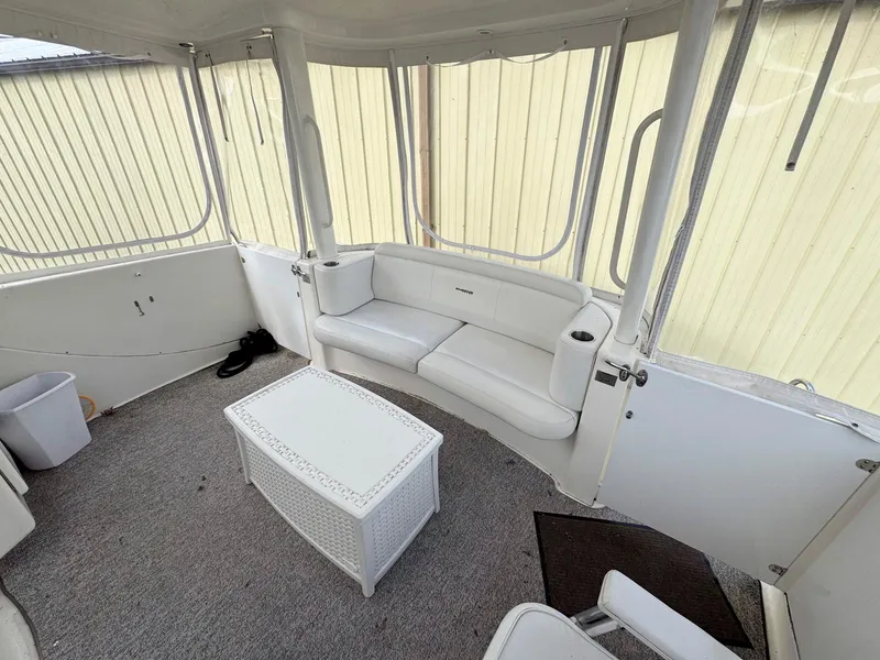 Slide: The Image of 2003 Silverton 39 Motor Yacht interior with white seating and table, enclosed by windows. - 12