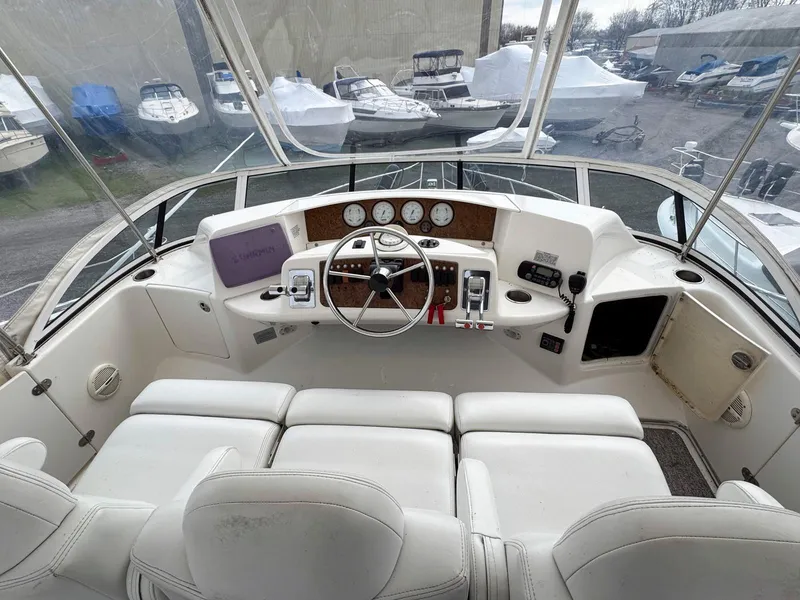 Slide: The Image of 2003 Silverton 39 Motor Yacht helm with white seating and navigation controls. - 15