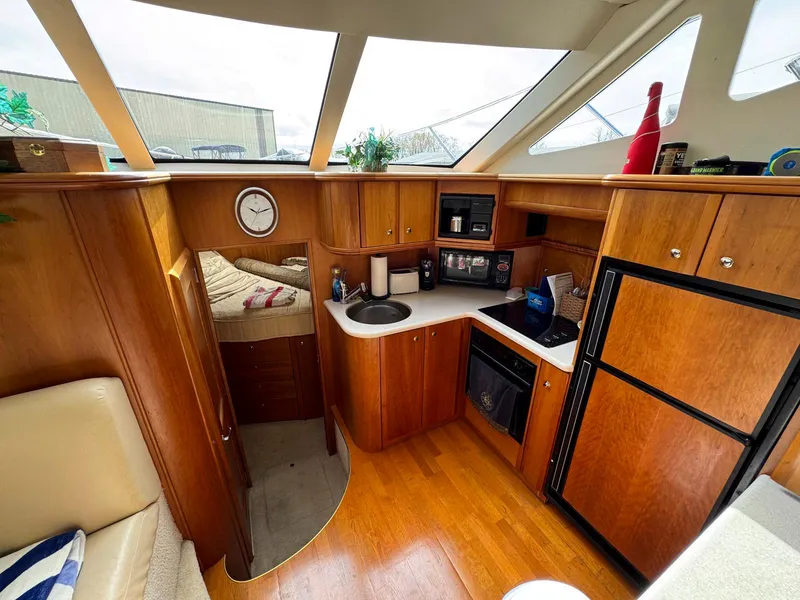 Slide: The Image of Interior of 2003 Silverton 39 Motor Yacht with kitchen, bed, and wooden cabinetry. - 20