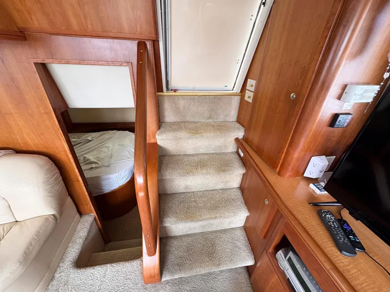 Slide: The Image of Interior of 2003 Silverton 39 Motor Yacht with carpeted stairs and wooden accents. - 22