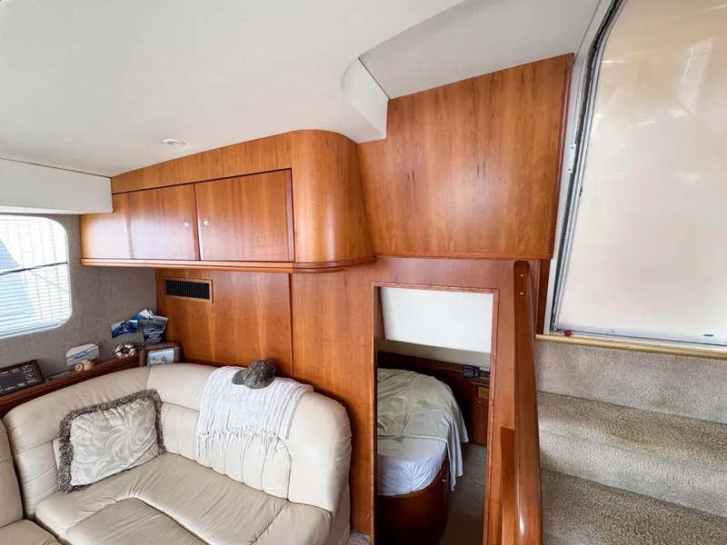 Slide: The Image of Interior of 2003 Silverton 39 Motor Yacht with wood paneling and cozy seating area. - 23