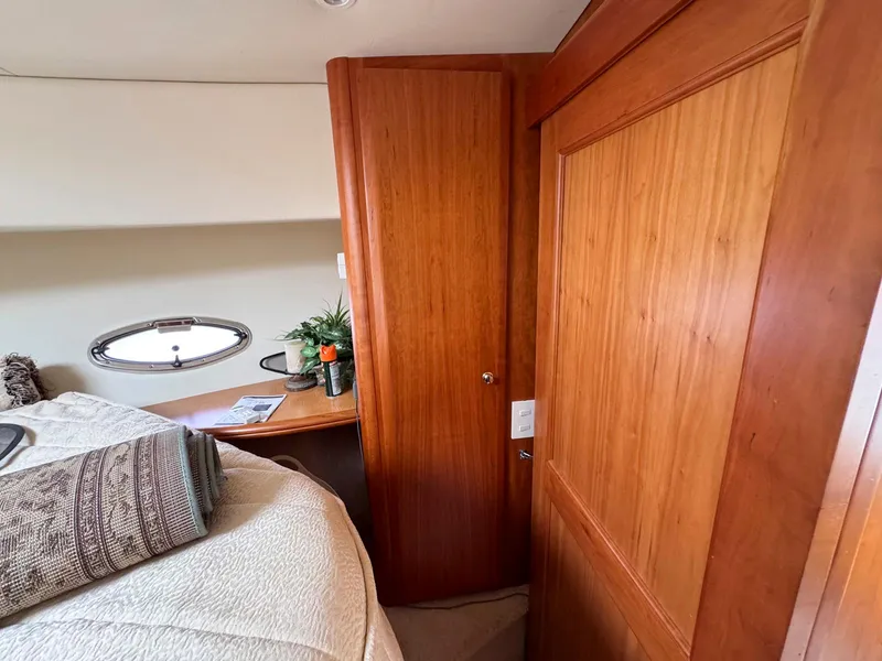 Slide: The Image of 2003 Silverton 39 Motor Yacht interior with wooden cabinetry and cozy bedding. - 29