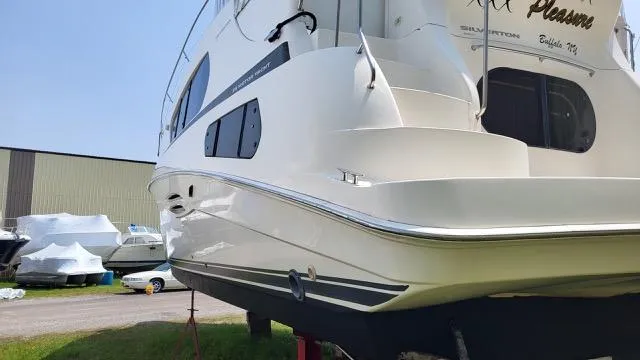 Slide: The Image of 2003 Silverton 39 Motor Yacht on land, showcasing sleek design and white exterior. - 3