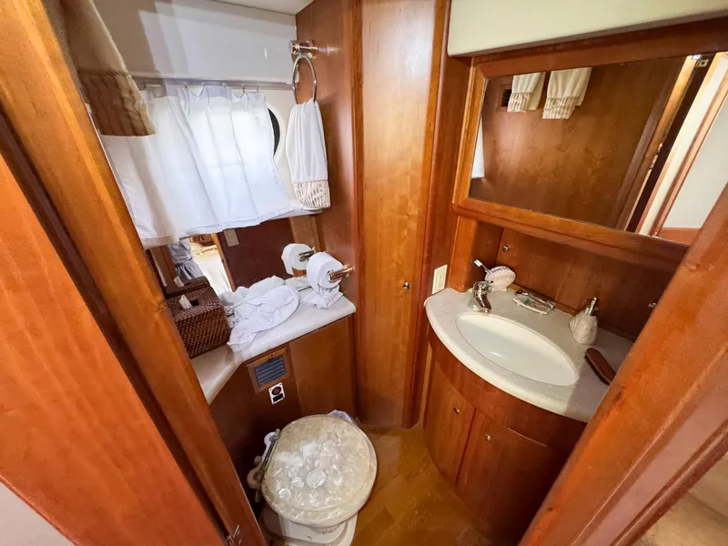 Slide: The Image of 2003 Silverton 39 Motor Yacht bathroom with wooden cabinetry and white fixtures. - 31