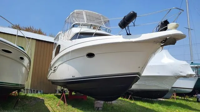 Slide: The Image of 2003 Silverton 39 Motor Yacht on land, white exterior, blue sky background. - 4
