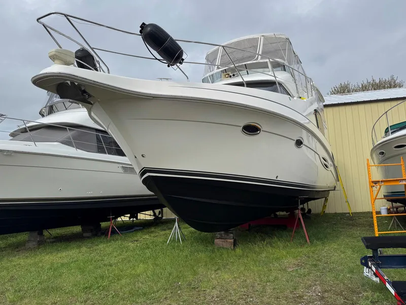 Slide: The Image of 2003 Silverton 39 Motor Yacht on land, displayed near a yellow building. - 7