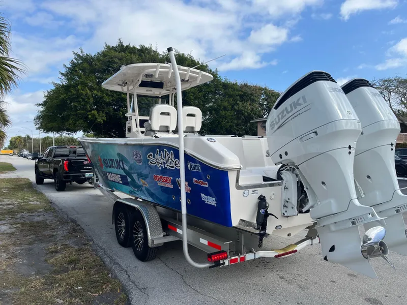 Slide: The Image of 2025 Sea Chaser 30 HFC CC boat on trailer with dual Suzuki engines, parked on roadside. - 15