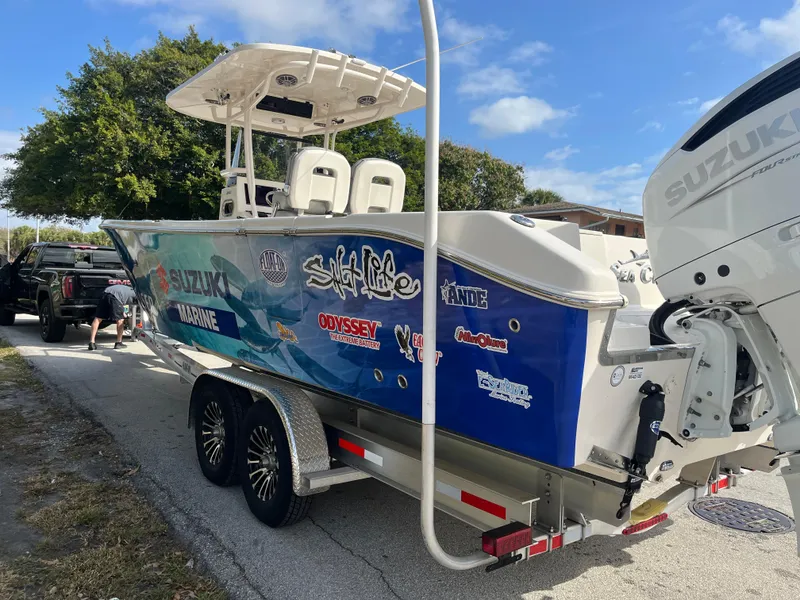Slide: The Image of 2025 Sea Chaser 30 HFC CC boat on trailer, featuring Suzuki engine and vibrant decals. - 5