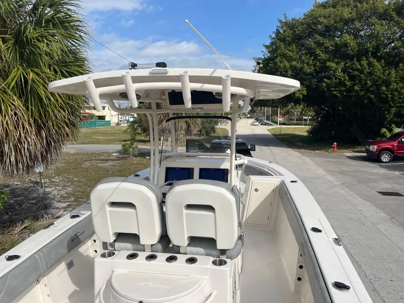 Slide: The Image of 2025 Sea Chaser 30 HFC CC boat with dual seats and T-top, parked on a sunny day. - 6