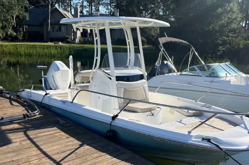 Slide: The Image of 2019 Boston Whaler 210 Dauntless boat docked by the water. - 1