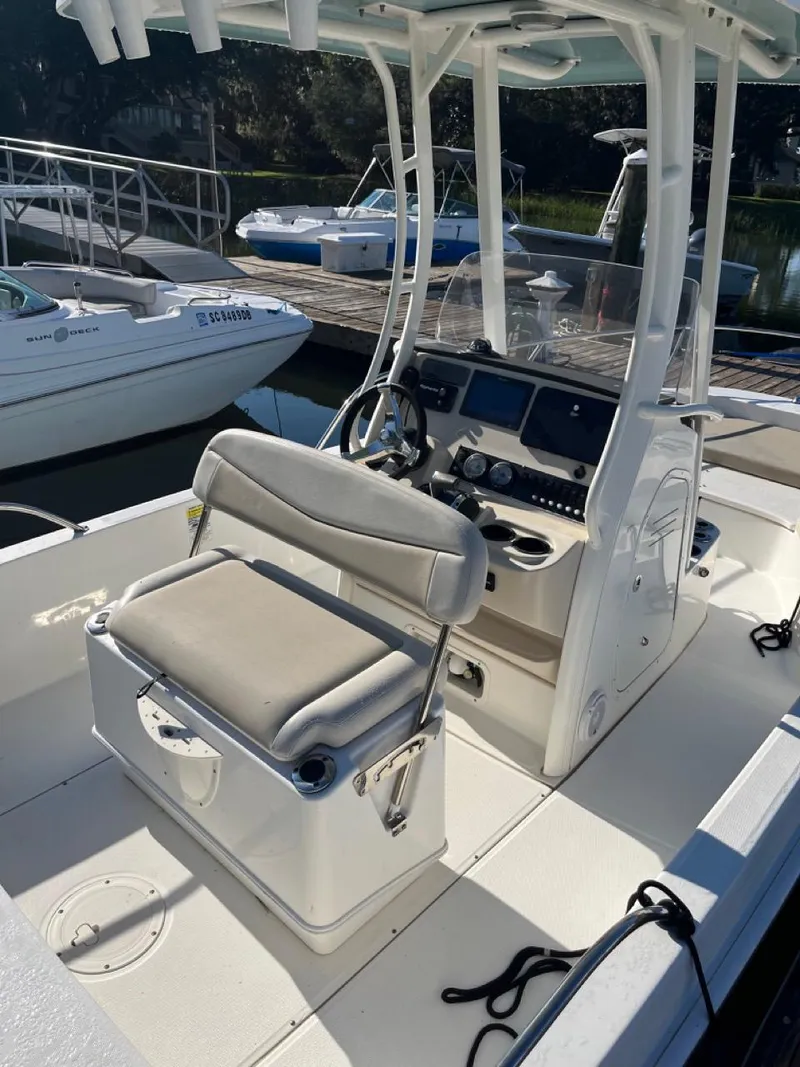 Slide: The Image of 2019 Boston Whaler 210 Dauntless boat interior with helm and seating at dock. - 5