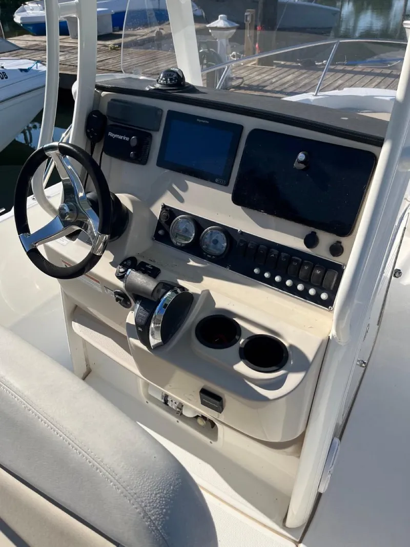Slide: The Image of 2019 Boston Whaler 210 Dauntless boat console with steering wheel and navigation controls. - 6