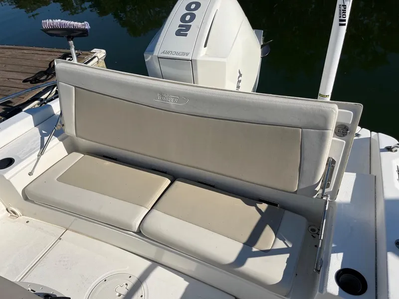 Slide: The Image of 2019 Boston Whaler 210 Dauntless boat seat and engine, docked on calm water. - 8