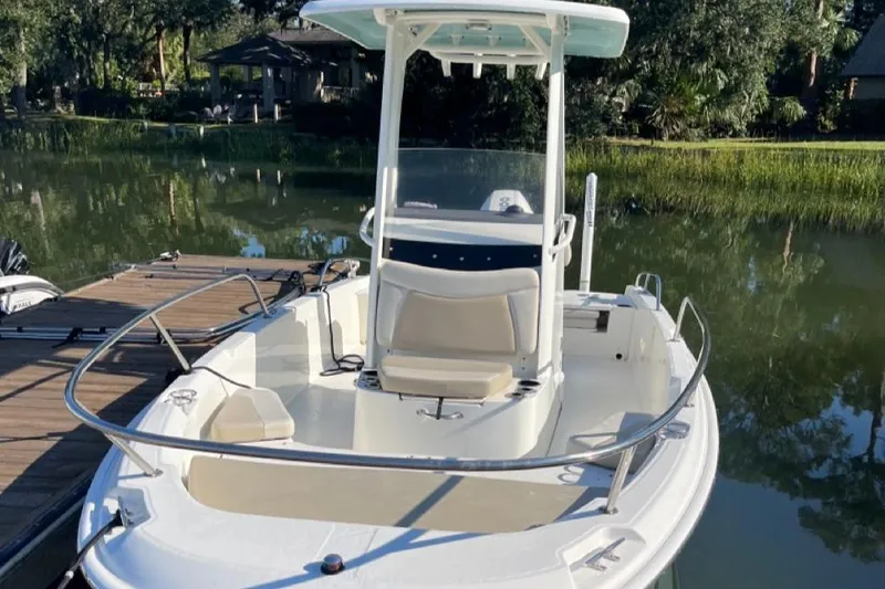 Slide: The Image of 2019 Boston Whaler 210 Dauntless boat docked on a serene lake. - 9