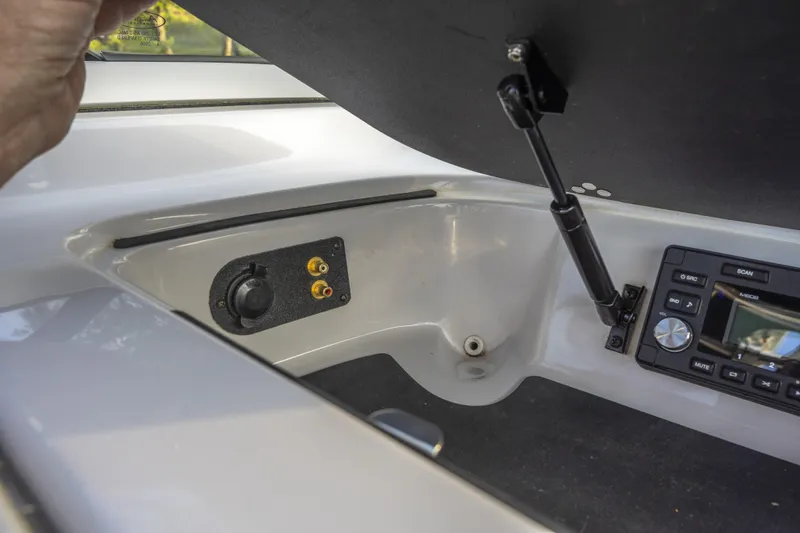 Slide: The Image of 2007 Correct Craft Air Nautique 226 LE boat dashboard with audio controls and storage compartment. - 12