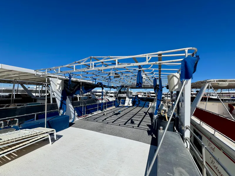 Slide: The Image of Lakeview Full Ownership 1993 houseboat with spacious deck and canopy under clear blue sky. - 16