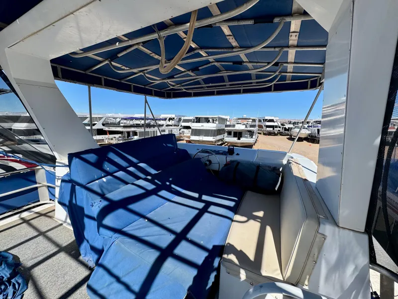 Slide: The Image of 1993 Lakeview Full Ownership boat with blue canopy and seating area, docked under clear skies. - 17