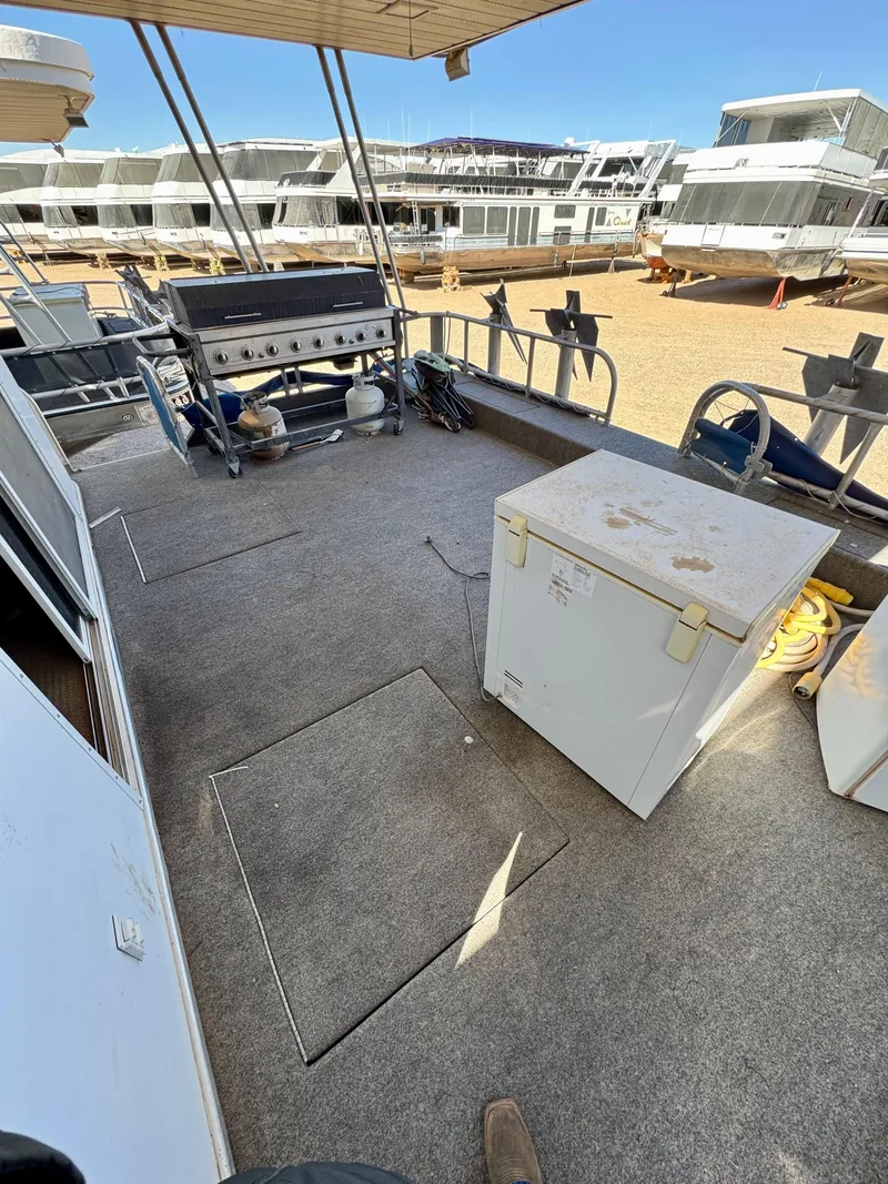 Slide: The Image of 1993 Lakeview Full Ownership boat deck with grill and storage box, docked in a marina. - 2