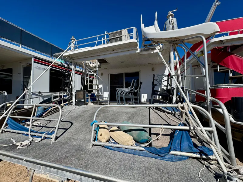 Slide: The Image of 1993 Lakeview Full Ownership houseboat with upper deck and slide, docked under clear blue sky. - 20