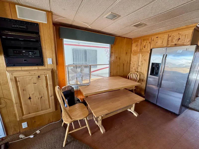 Slide: The Image of Cozy kitchen with wooden cabinets, dining table, and stainless steel refrigerator in a Lakeview 1993 model. - 5