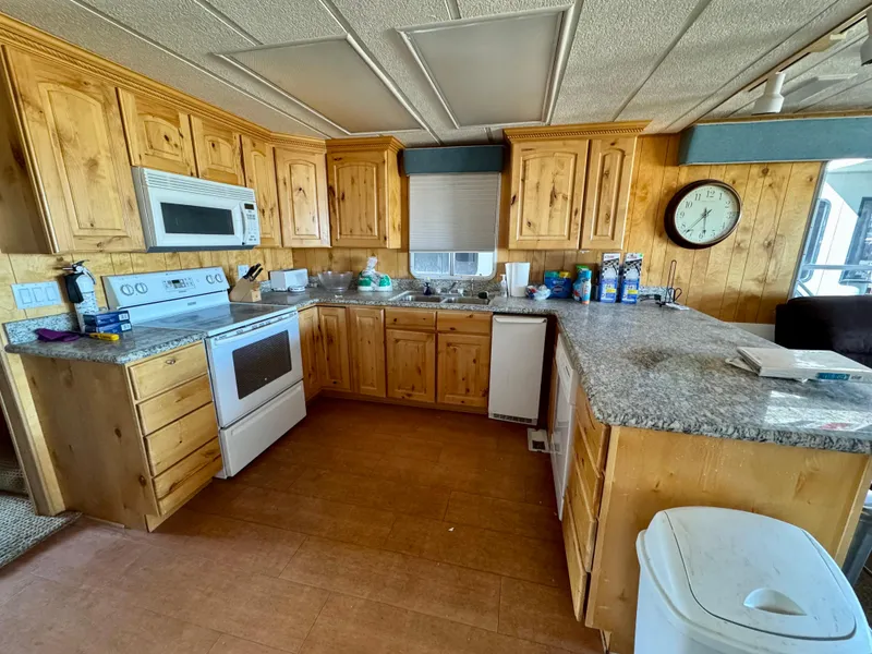 Slide: The Image of Spacious kitchen with wooden cabinets, granite countertops, and modern appliances in a Lakeview model. - 6
