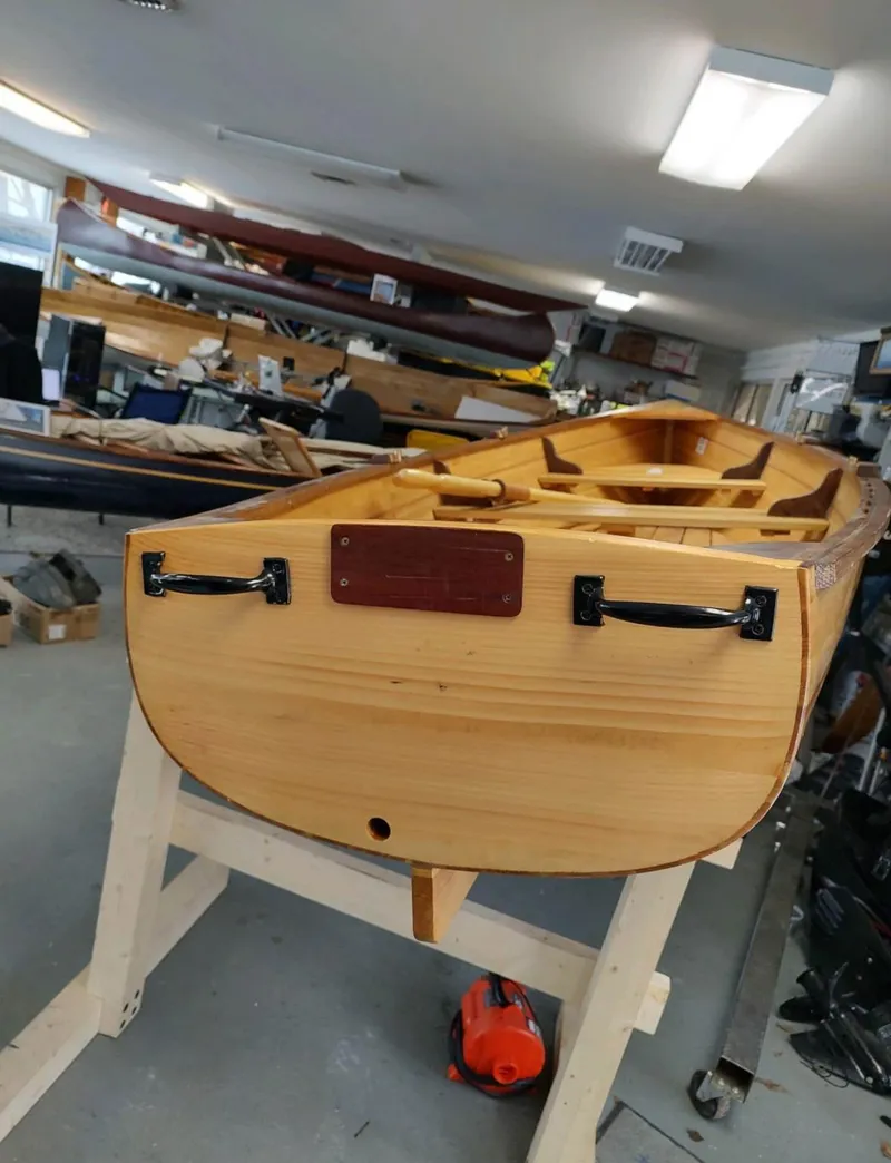 Slide: The Image of Custom Cedar Strip boat, 2016 model, in workshop setting on a wooden stand. - 4