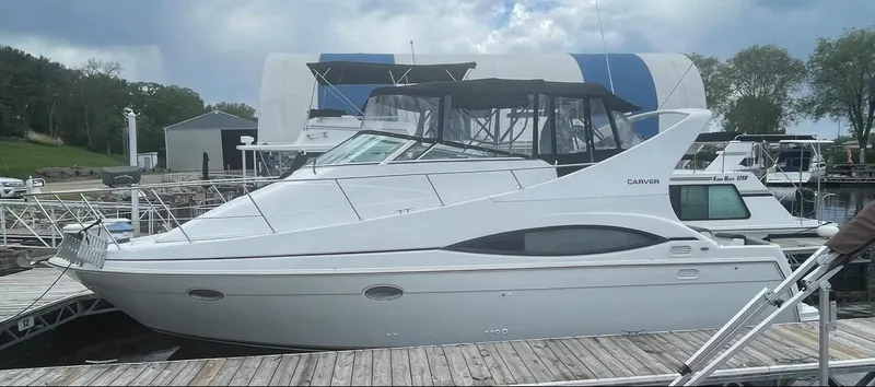 Slide: The Image of 1997 Carver 350 Mariner yacht docked at marina under cloudy sky. - 4