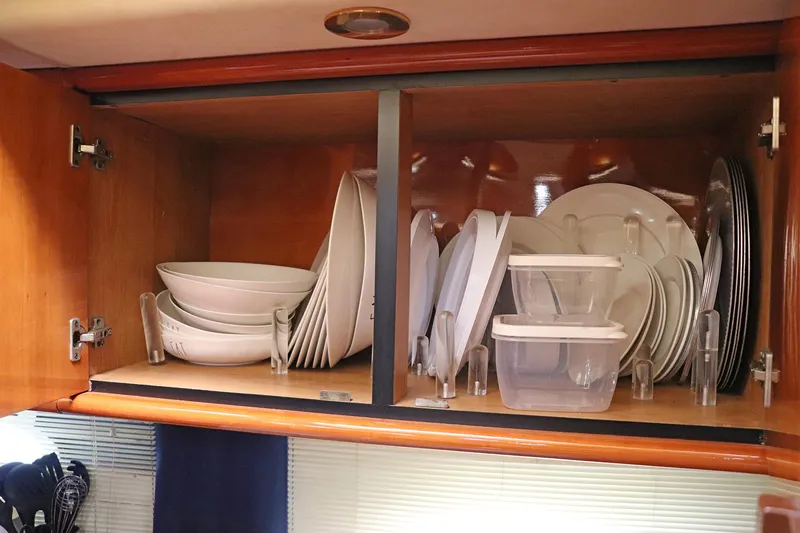 Slide: The Image of Cabinet with dishes and glasses inside a 2000 Sunseeker Predator 74 yacht. - 54