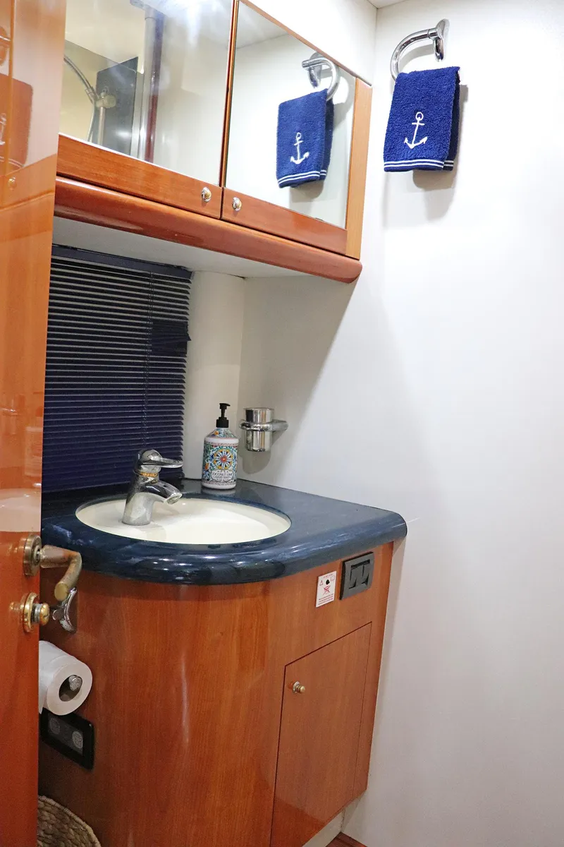 Slide: The Image of Luxurious bedroom interior of 2000 Sunseeker Predator 74 yacht with nautical-themed decor. - 64