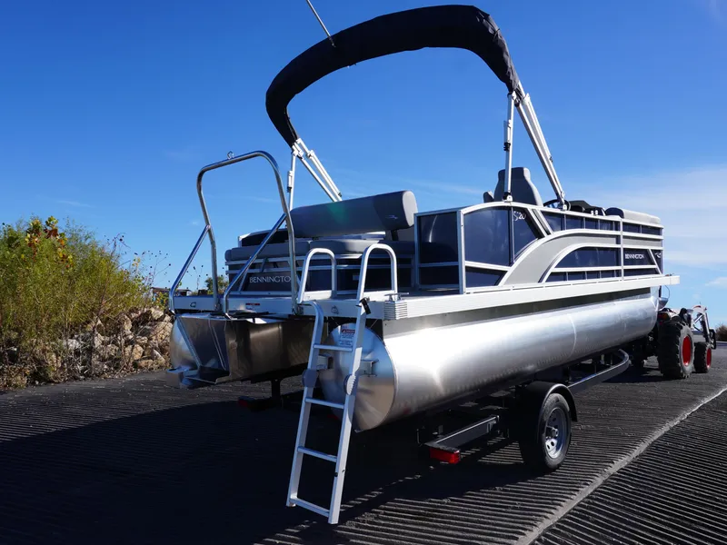 Slide: The Image of 2025 Bennington 20 SSB pontoon boat on trailer under clear blue sky. - 3