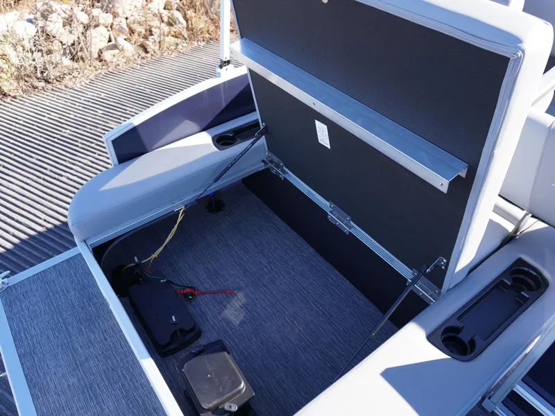 Slide: The Image of 2025 Bennington 20 SSB boat storage compartment with open lid and visible battery. - 6