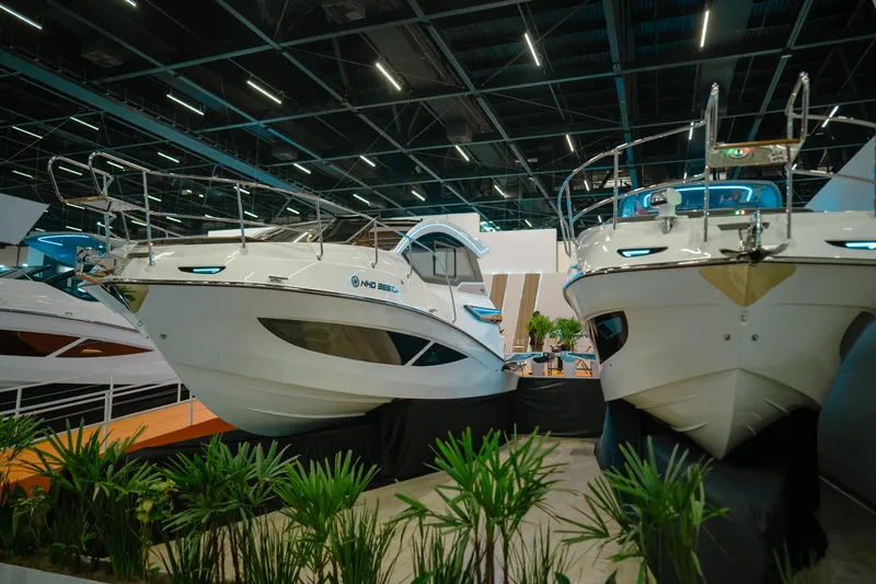 Slide: The Image of 2025 NHD 365 HT PLUS boats displayed indoors at a boat show. - 2